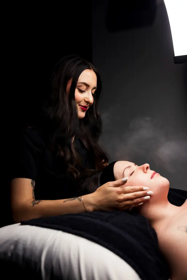 An esthetician working with a patient during a facial