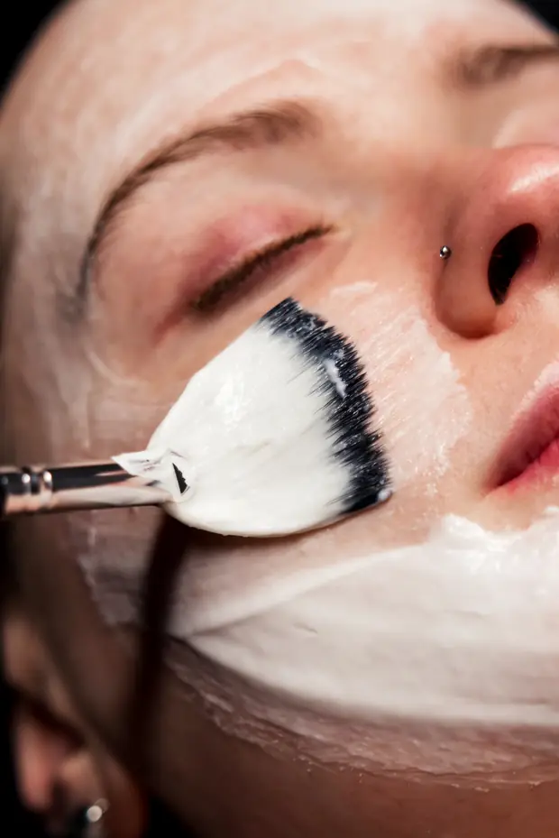 A treatment mask being applied with a fan brush