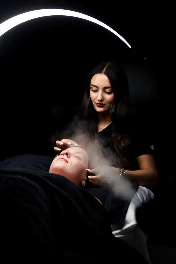 An esthetician performing a steam facial